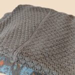 Detalle cuello de Poncho EMMA de baby alpaca en color visón, prenda ligera, elegante y artesanal hecha en Perú.